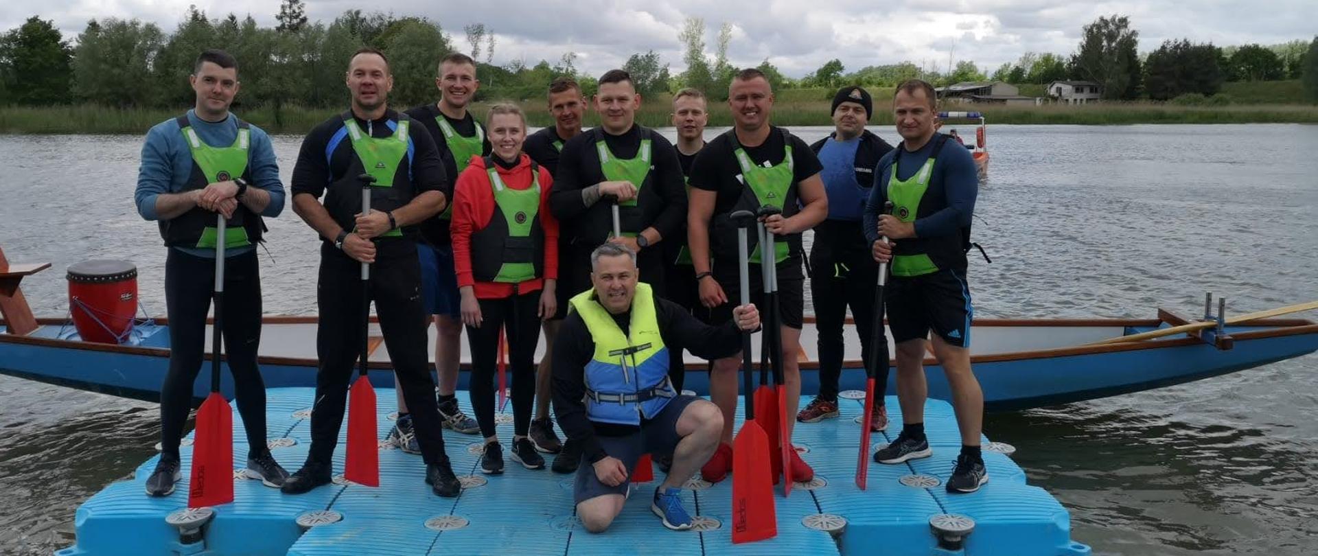 Na zdjęciu znajduje się reprezentacja Komendy Powiatowej PSP w Chełmnie przed startem w regatach smoczych łodzi. Zdjęcie wykonano na tle Jeziora Starogrodzkiego. 
