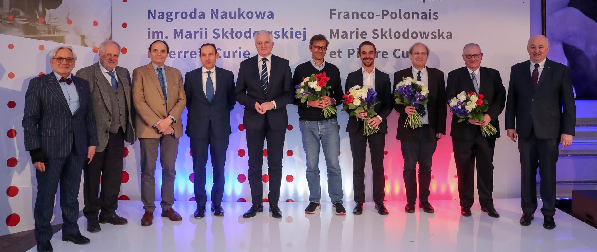 Zdjęcie zbiorowe laureatów nagrody, między nimi stoi minister Gowin.