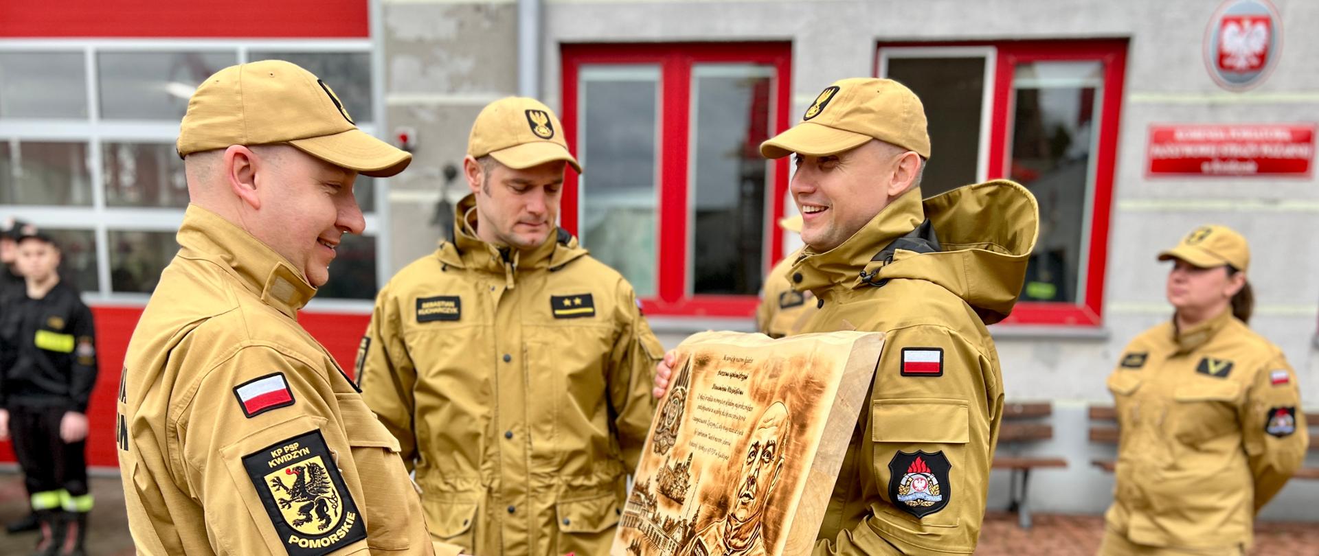 Funkcjonariusze KP PSP w Kwidzynie wręczają prezent funkcjonariuszowi, który przeszedł na zaopatrzenie emerytalne.