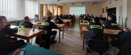 Zdjęcie przedstawia strażaków w Sali szkoleniowej w trakcie prowadzonych zajęć teoretycznych przez funkcjonariusza PSP