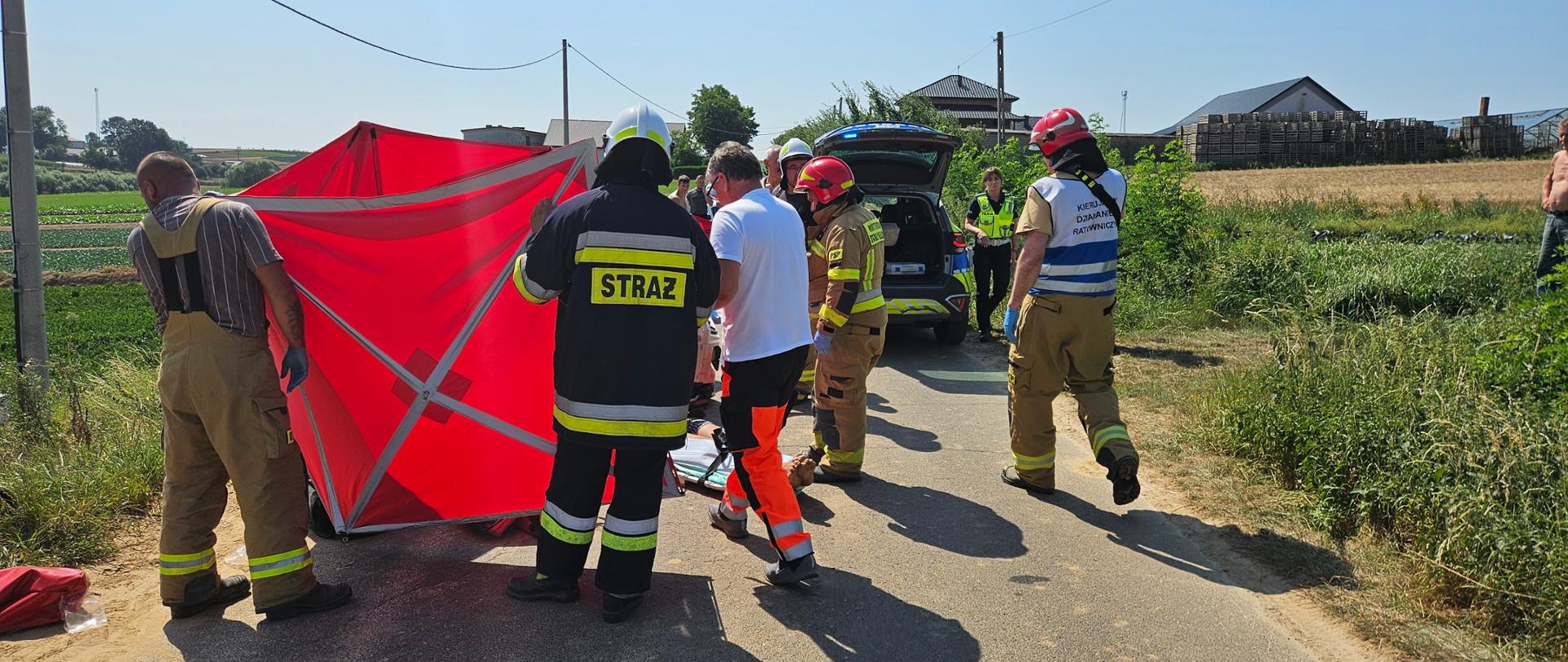 Strażacy udzielają pomocy poszkodowanej osobie