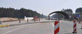 Budowa konstrukcji górnego przejścia dla zwierząt z blachy falistej. Nad jedną z jezdni konstrukcja jest już widoczna, nad drugą jeszcze nie.