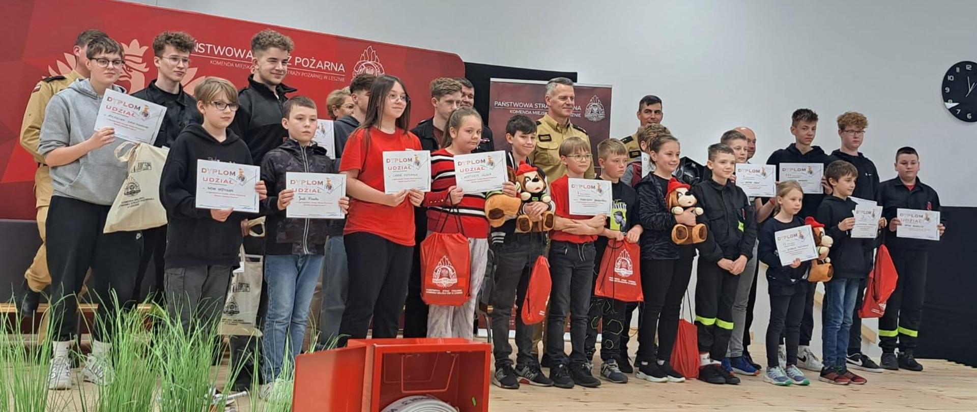 Grupa dzieci i młodzieży z nagrodami pozująca do zdjecia.