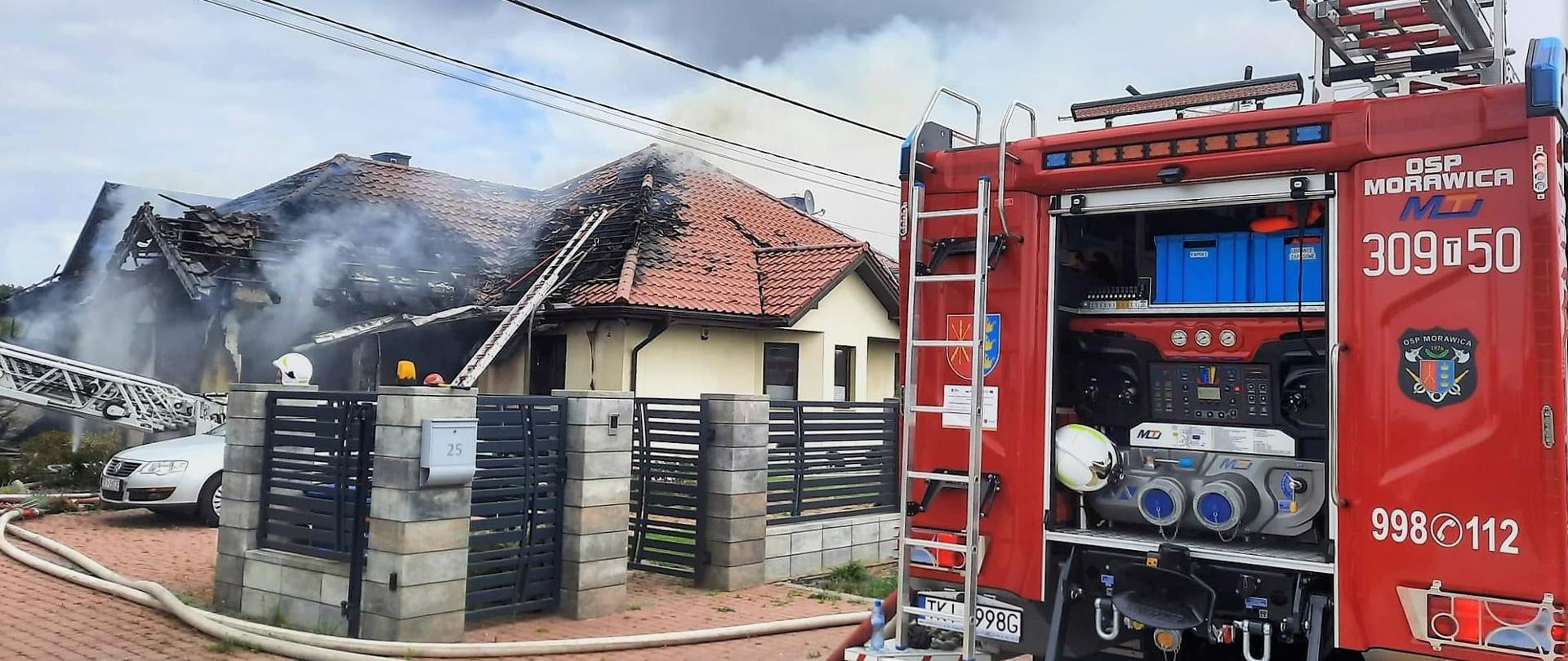 Zdjęcie przedstawia spalony budynek mieszkalny a z prawej strony widać fragment wozu pożarniczego.