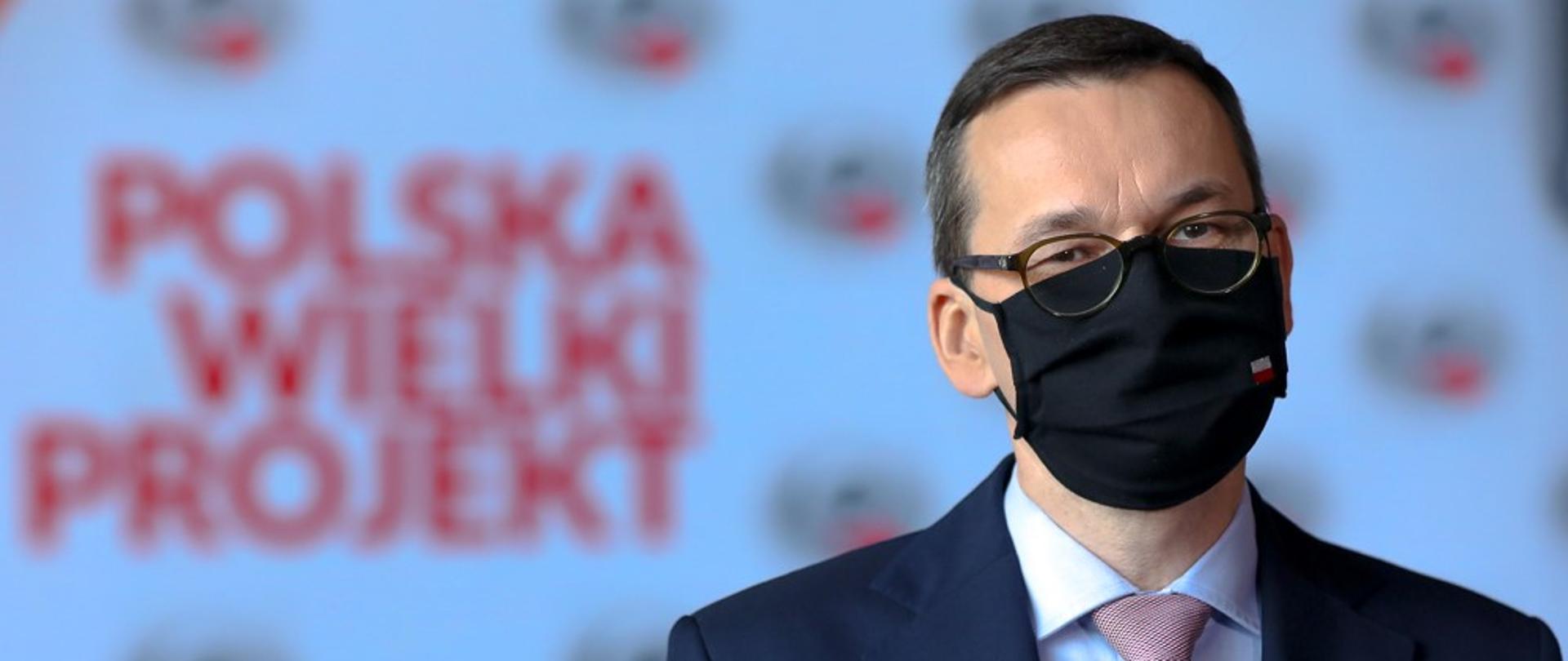 Premier Mateusz Morawiecki na tle loga Polska Wielki Projekt.