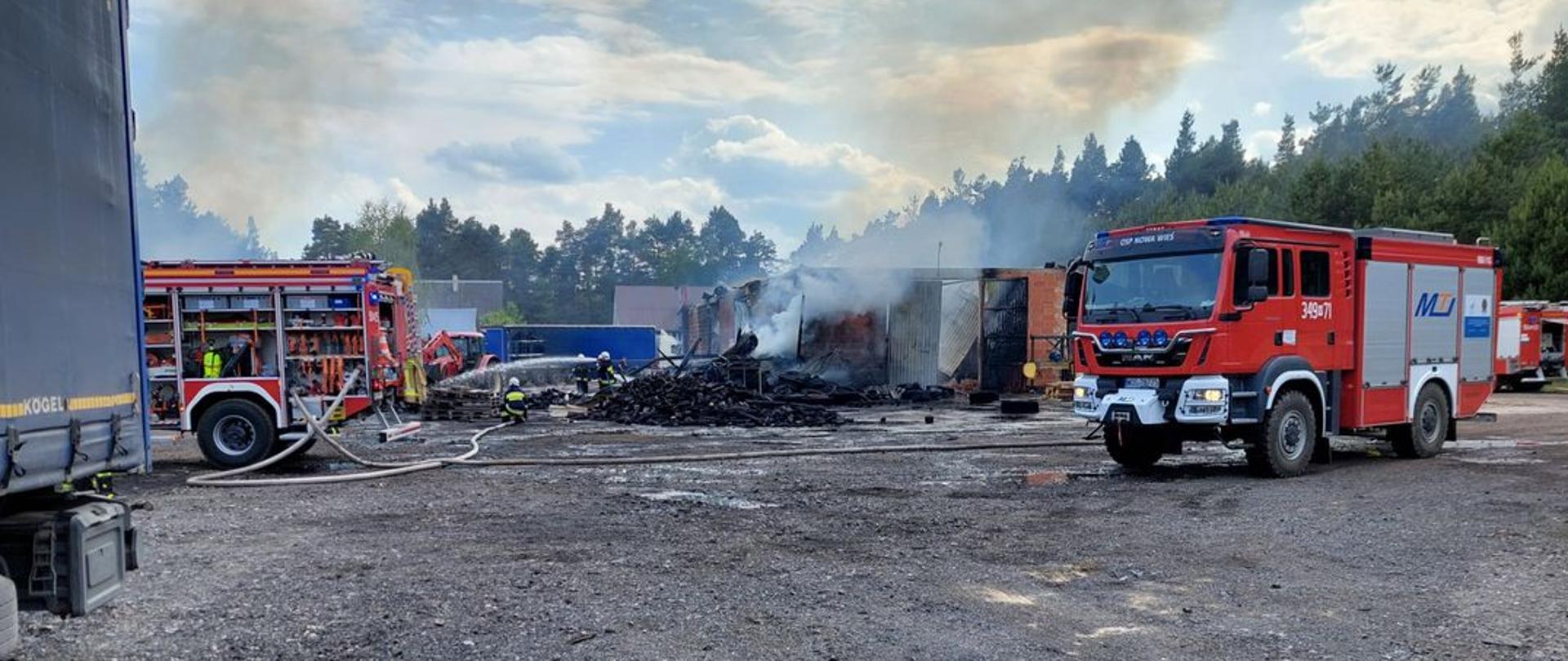 Strażacy dogaszają pożar murowanej hali. 