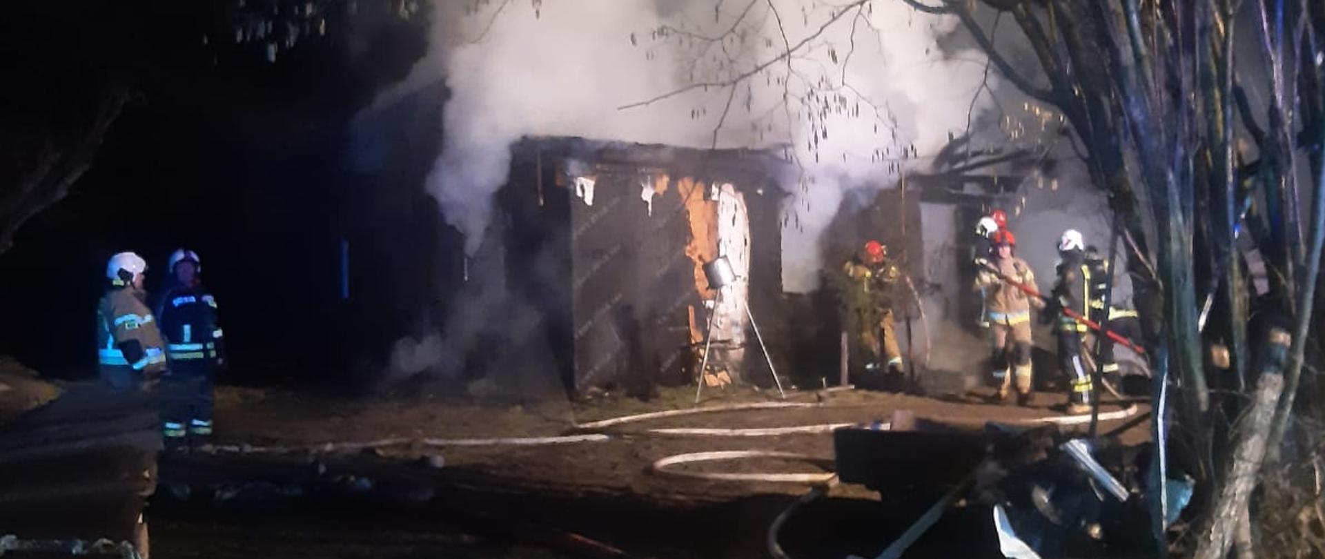 Na zdjęciu widać pożar budynku mieszkalnego w Dreństwie. W tle widać strażaków