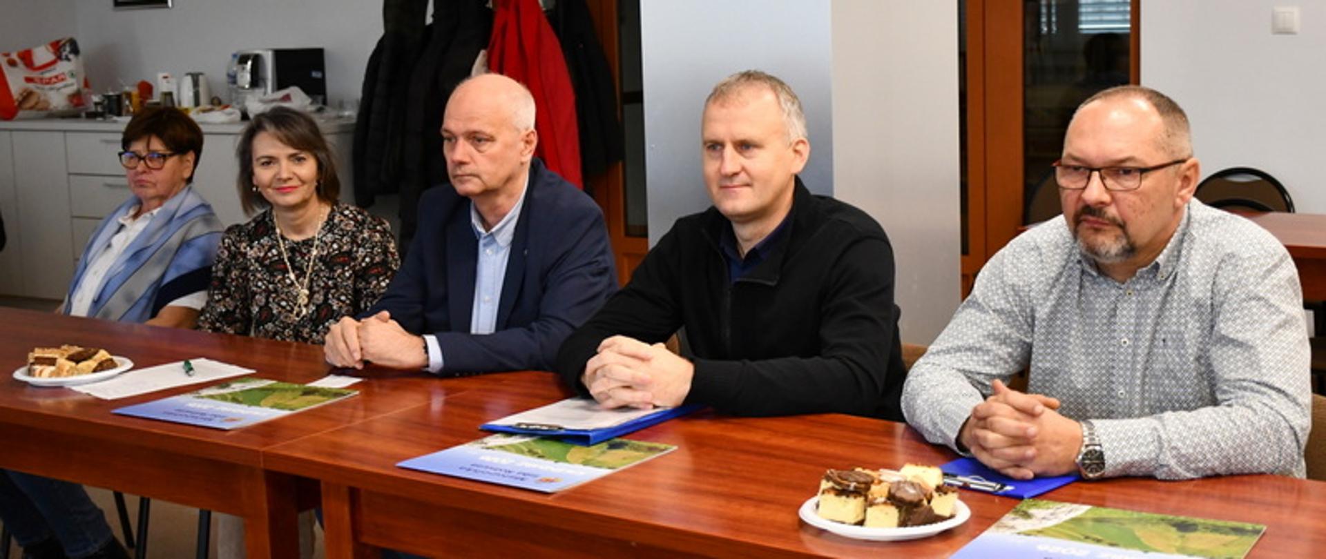 Grupa osób siedząca za stołem konferencyjnym