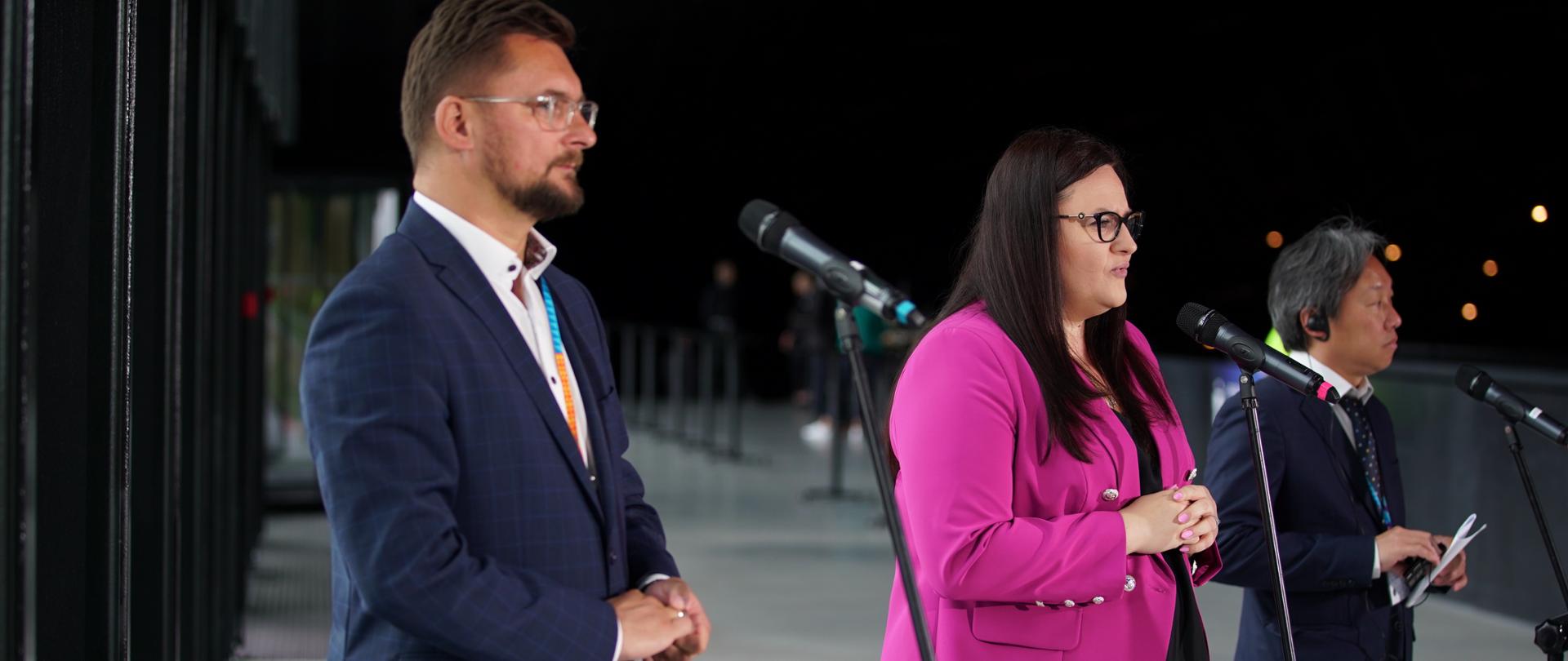 Trzy osoby stoją przed mikrofonami. Od lewej prezydent Katowic Marcin Krupa, wiceminister Małgorzata Jarosińska- Jedynak, przedstawiciel UN-Habitat Neil Khor.