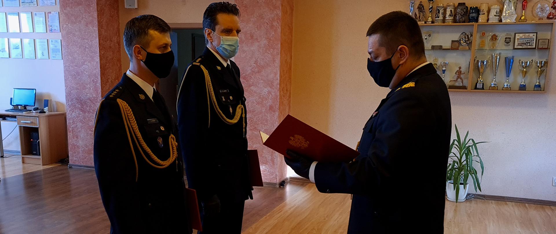 Zdjęcie przedstawia uroczyste zdanie obowiązków służbowych Komendanta Powiatowego PSP w Kłobucku przez st. bryg. Roberta Ladrę oraz przyjęcie obowiązków służbowych Komendanta Powiatowego PSP w Kłobucku przez st.kpt. Karola Wersa.