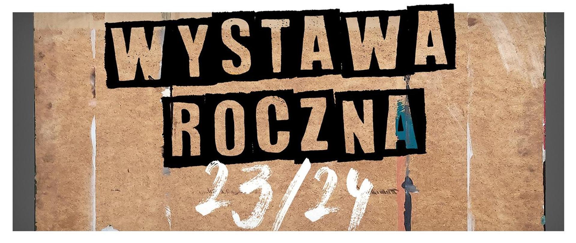 napis "wystawa roczna 23/24" na desce ze śladami farby
