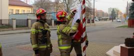 Poczet flagowy złożony ze strażaków JRG w Bielsku Podlaskim w umundurowaniu specjalnym podczas mocowania flagi do masztu.