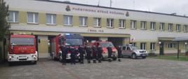 Na zdjęciu widać zmianę służbową z dowódcami oddających honor przy wozach bojowych na tle budynku Komendy Powiatowej Państwowej Straży Pożarnej w Wieluniu