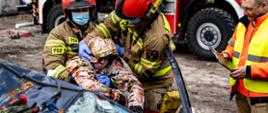 Strażacy ewakuujący poszkodowanego z rozbitego auta