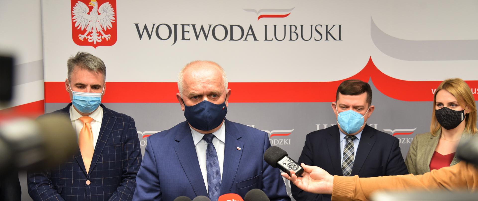 Wojewoda wypowiada się do mikrofonów, za nim stoją prezydenci 