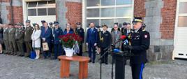 Przemawiający st. bryg. Jarosław Tomczyk, w tle zaproszeni goście oraz funkcjonariusze.