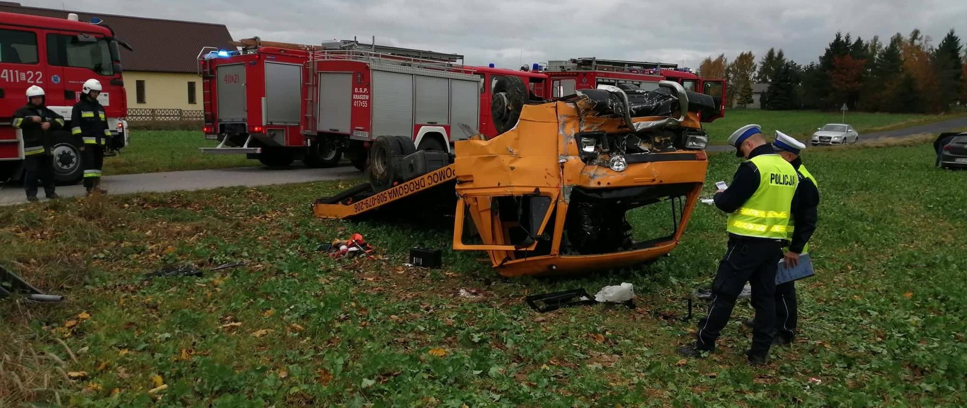 W centralnej części zdjęcia widoczny samochód ciężarowy, po dachowaniu