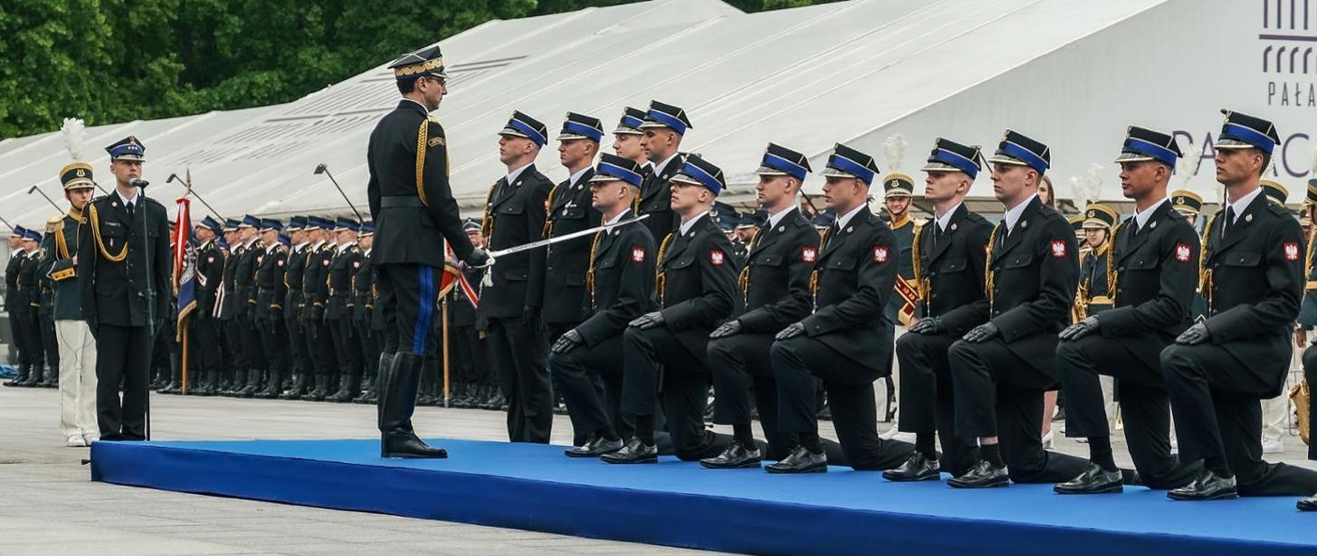 Zdjęcie przedstawia Komendanta Głównego dokonującego mianowania strażaków na pierwszy stopień oficerski