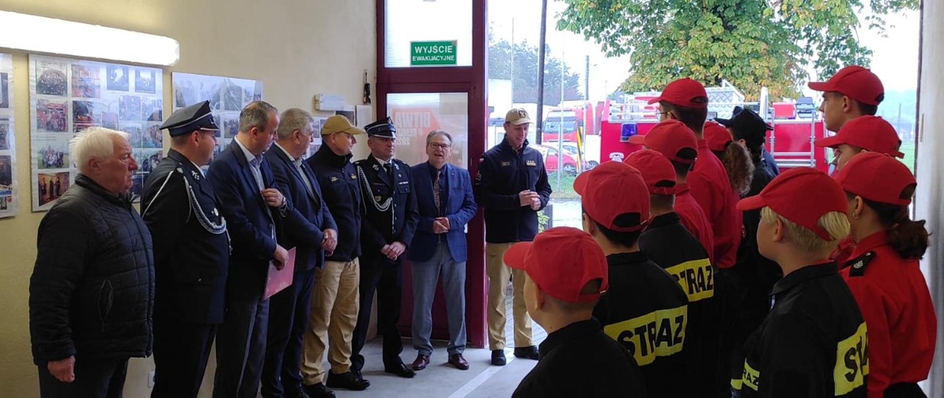 grupa dzieci i dorosłych stoi w korytarzu remizy 