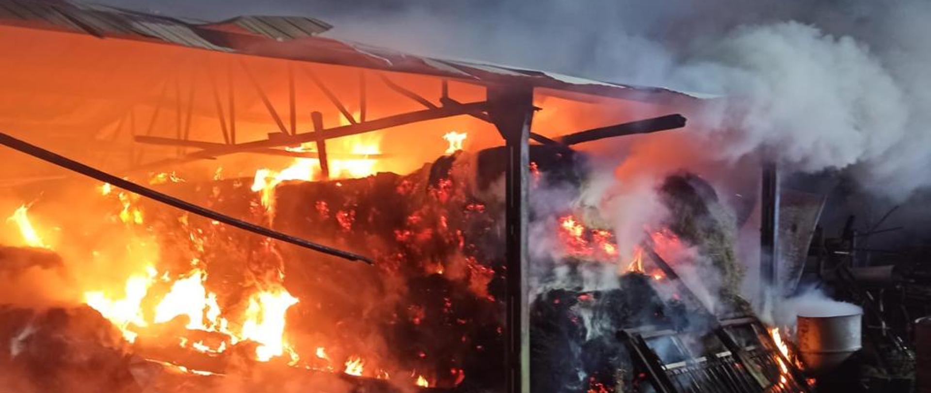 Na zdjęciu widać palące się siano pod wiatą.