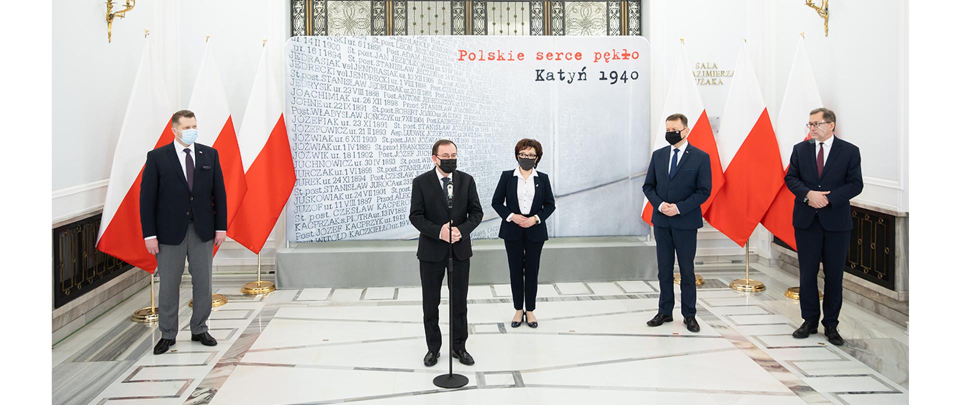 Na zdjęciu widać przemawiającego ministra Mariusza Kamińskiego. W tle stoją marszałek Sejmu Elżbieta Witek, minister Przemysław Czarnek, minister Mariusz Błaszczak i prezes Jarosław Szarek.