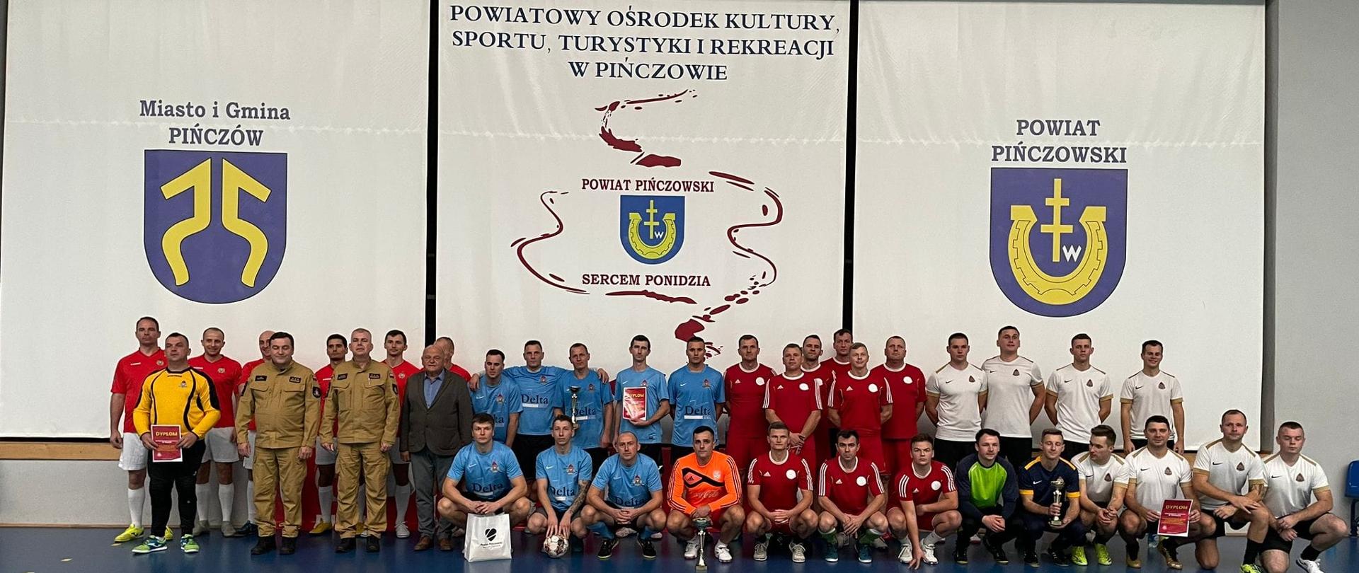 Wszyscy uczestnicy zawodów Finałowych Wojewódzkich Mistrzostw strażaków w halową piłkę nożną o puchar Świętokrzyskiego Komendanta Wojewódzkiego Państwowej Straży Pożarnej na jednym zdjęciu pozują po zakończeniu rywalizacji.