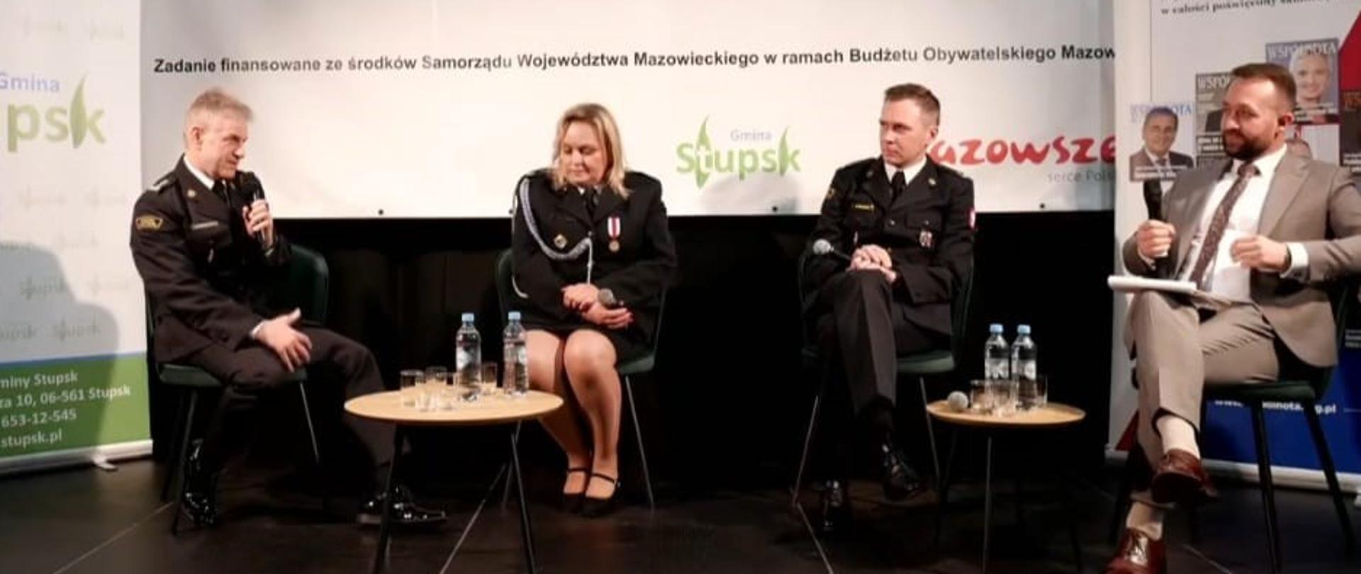 Uczestnicy panelu dyskusyjnego podczas rozmowy o znaczeniu działalności strażaków Państwowej i Ochotniczej Straży Pożarnej w życiu lokalnych społeczności. W spotkaniu uczestniczy Komendant Powiatowy PSP w Mławie st. bryg. Jarosław Andruszkiewicz.