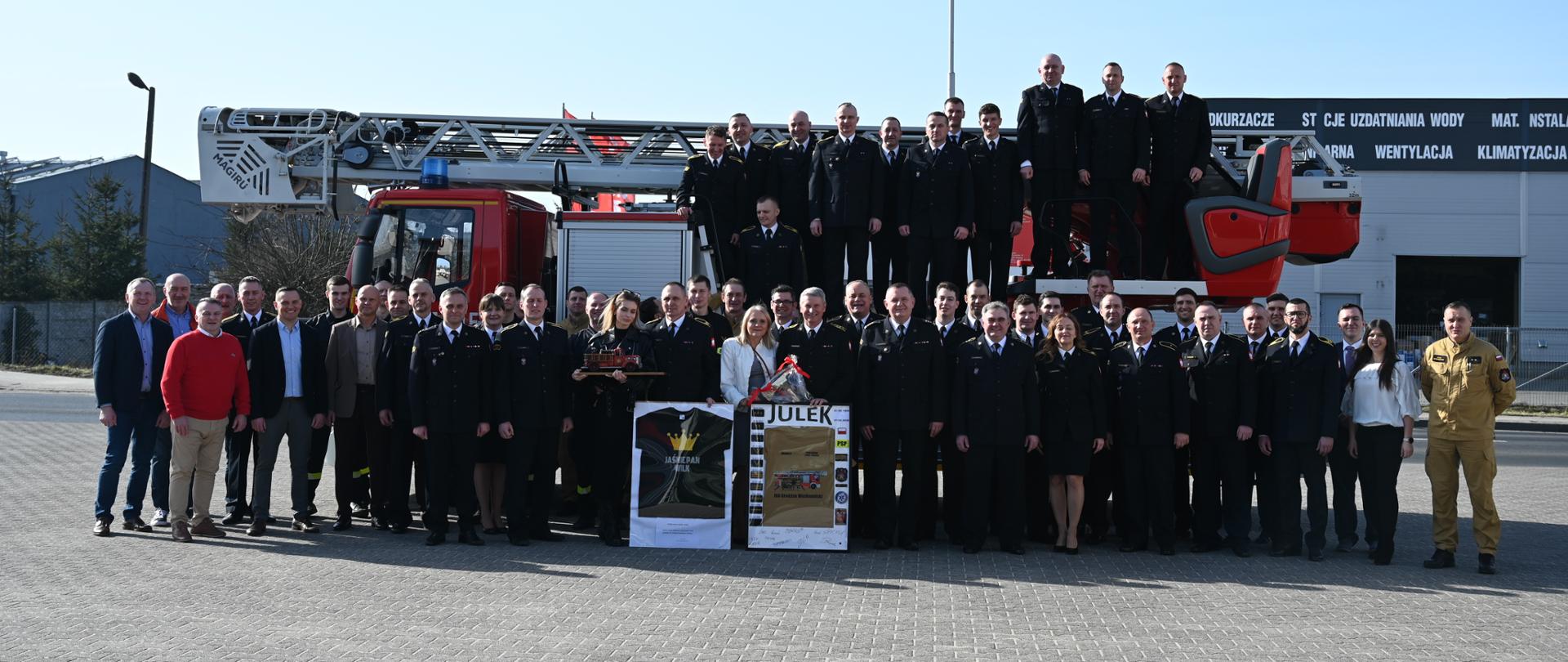 Przejście na zaopatrzenie emerytalne funkcjonariuszy Komendy. Zdjęcie grupowe na tle drabiny strażackiej 