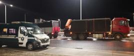 Na pierwszym planie (od lewej): oznakowany furgon mazowieckiej Inspekcji Transportu Drogowego. W tle: kontrolowany zespół pojazdów z przewożonym ładunkiem szamb betonowych.