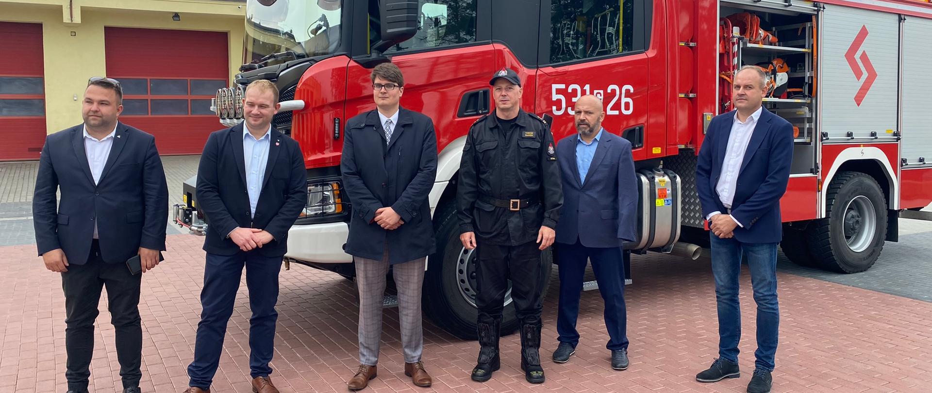 przed samochodem bojowym stoją działacze samorządowi, komendant powiatowy i wicewojewoda.