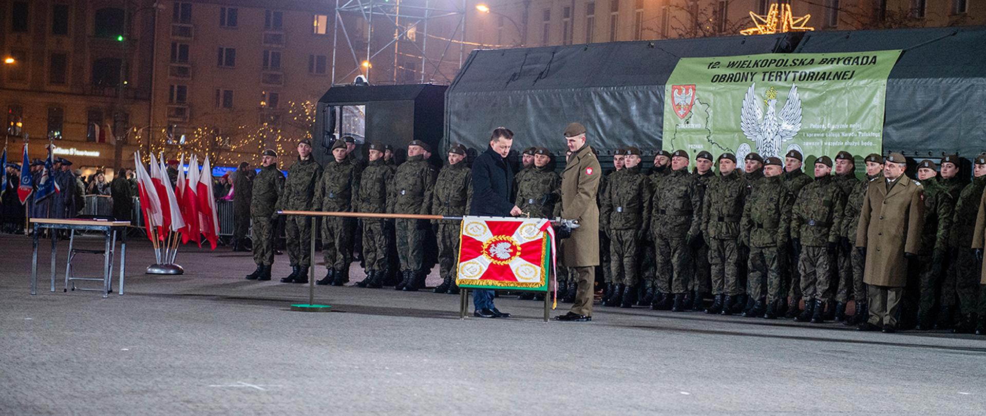 Minister Mariusz Błaszczak wręcza sztandar żołnierzom 12 Wielkopolskiej Brygady Obrony Terytorialnej podczas uroczystości w Poznaniu