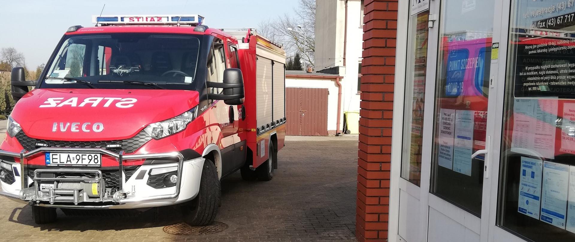 Zdjęcie przedstawia samochód OSP Bilew zaparkowany przed punktem szczepień na terenie gminy Sędziejowice