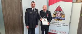 Komendant Powiatowy wręcza druhowi OSP pismo potwierdzające przyznanie świadczenia.