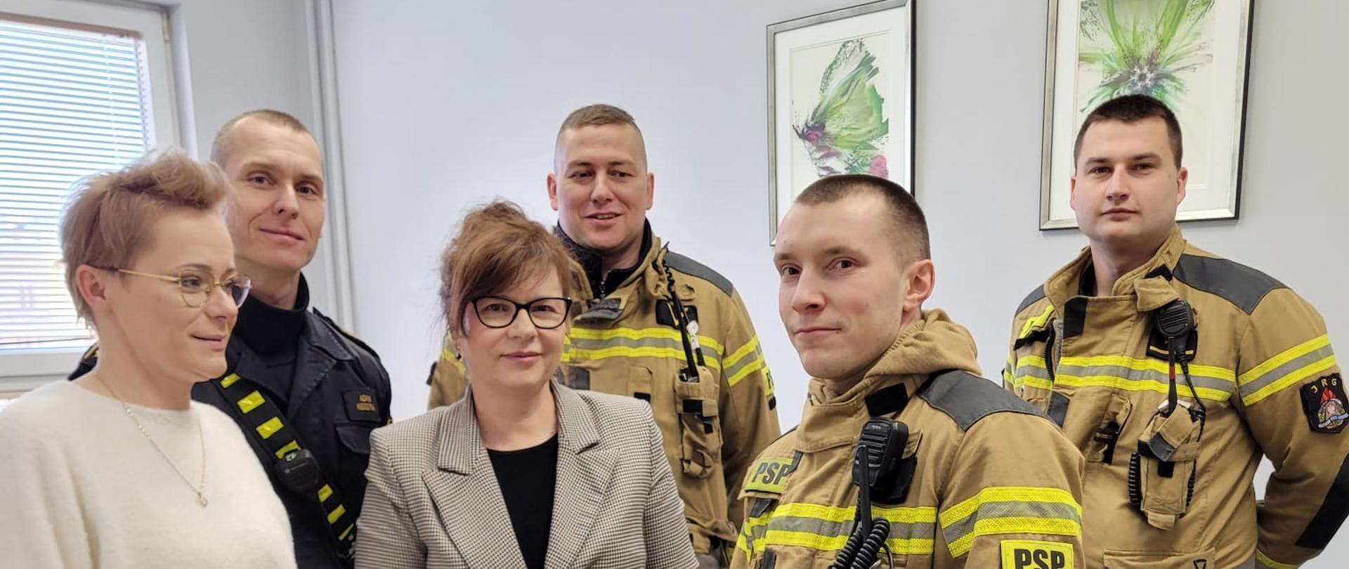 Strażacy przekazujący zebrane upominki dla dzieci.