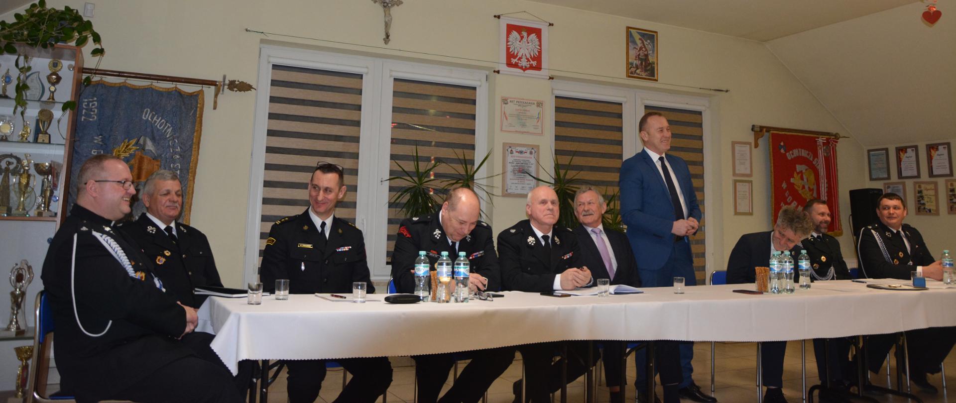 Zdjęcie przedstawia organizatorów i gości siedzący przy stole podczas spotkania sprawozdawczego Ochotniczej Straży Pożarnej w Górnie.