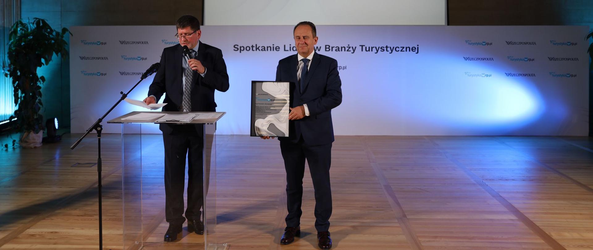 Minister Andrzej Gut-Mostowy z nagrodą Orzeł Rzeczpospolitej w ręku.