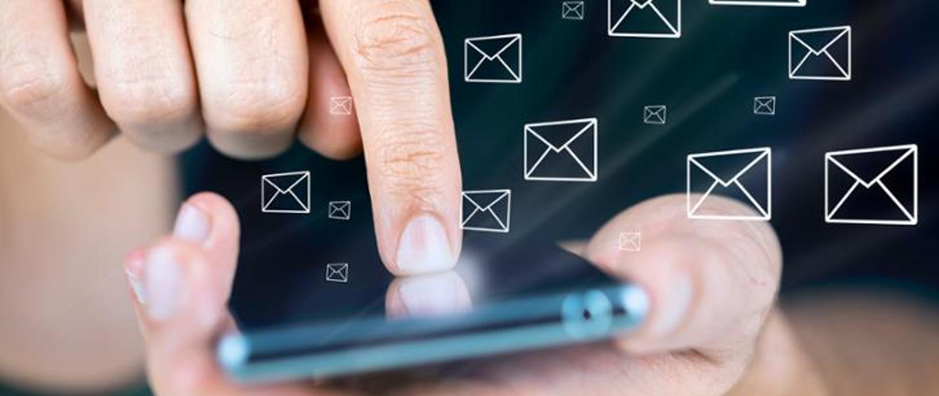 Telefon komórkowy trzymany w męskich dłoniach oraz ikonki sms.