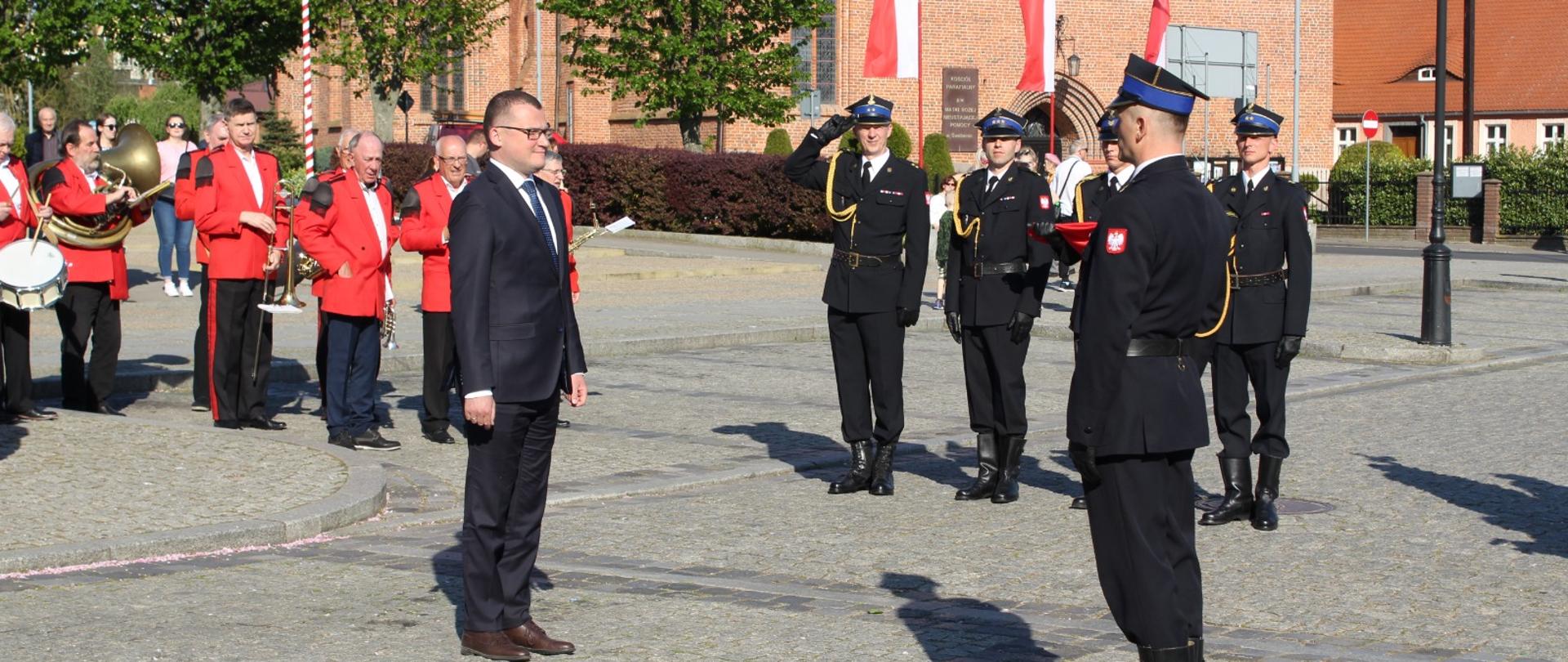 djęcie przedstawia pododziały podczas Powiatowe Obchody Dnia Strażaka 2023 oraz meldunek Dowódcy uroczystości dla Wice Ministra MSWiA