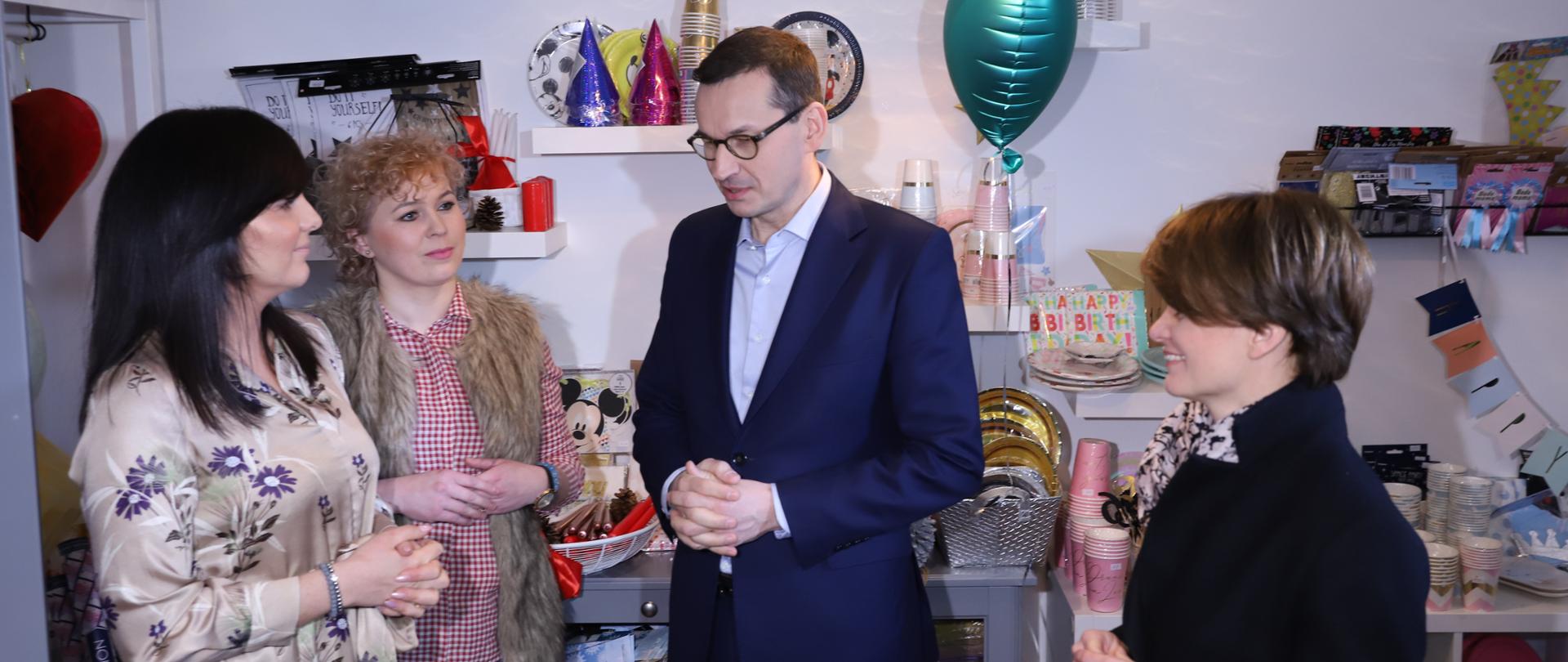 Premier Morawiecki, minister Emilewicz, Pani Dagmara i Pani Karolina stoją na tle wyposażenia sklepu