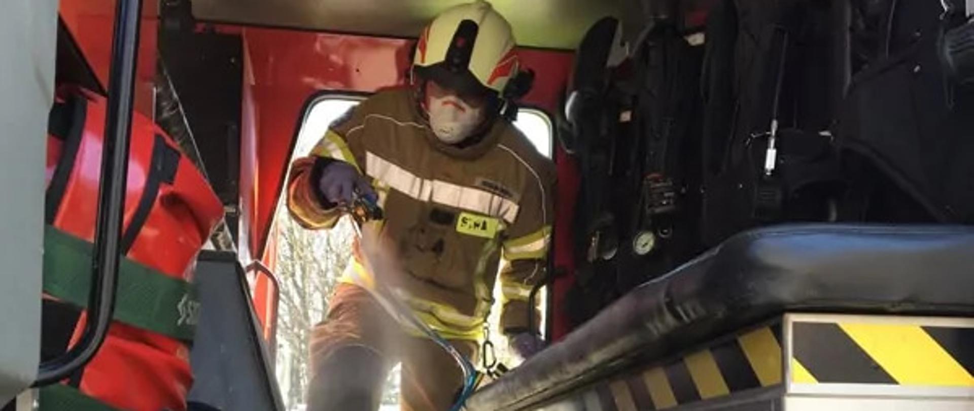 Strażak prowadzi dezynfekcje auta