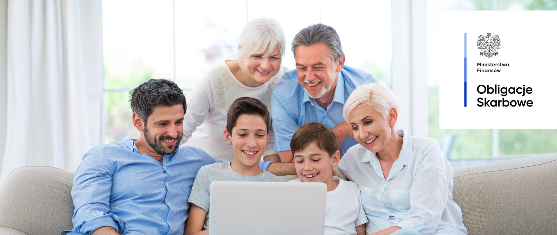 Sześć uśmiechniętych osób, patrzą na ekran komputera. Ministerstwo Finansów, Obligacje Skarbowe.