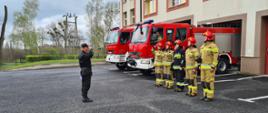Zdjęcie przedstawia oddanie honoru zmarłemu Policjantowi przez funkcjonariuszy Państwowej Straży Pożarnej przed Komendą Powiatową PSP w Kłobucku