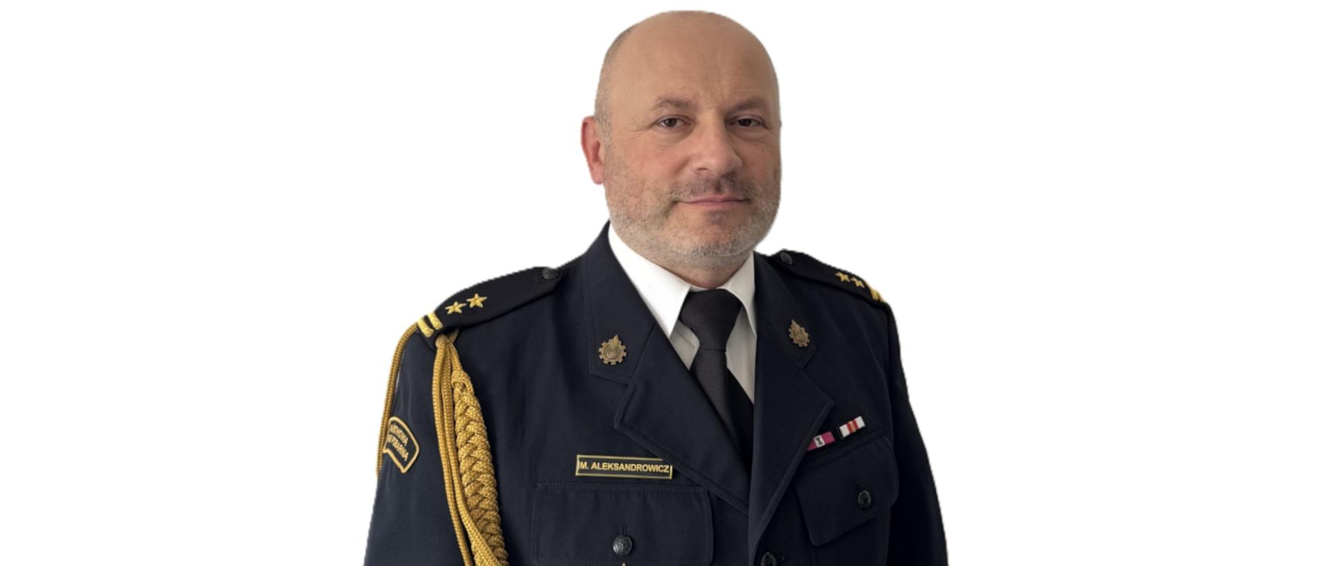 Na zdjęciu widać mężczyznę w ciemnym mundurze służbowym z odznaczeniami i pagonami. Stoi na jasnym tle i patrzy w stronę aparatu z neutralnym wyrazem twarzy.
