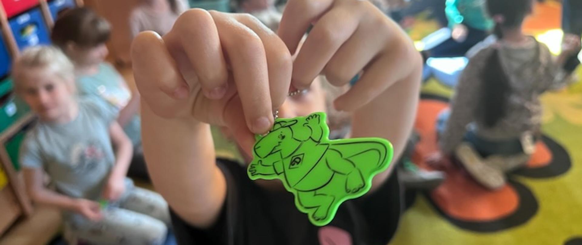 
Chłopiec pokazuje zawieszkę Dinusia
