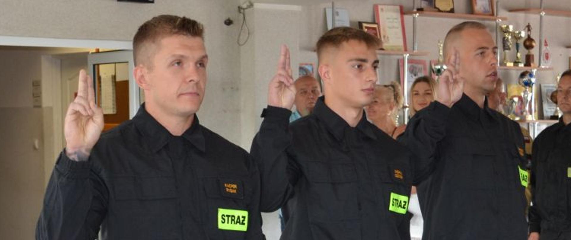 strażacy składają ślubowanie unosząc prawą rękę ze złączonymi palcami