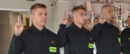 strażacy składają ślubowanie unosząc prawą rękę ze złączonymi palcami