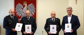 Zdjęcie przedstawia przedstawicieli straży państwowej i osp oraz władze miasta trzymających podpisane dokumenty.