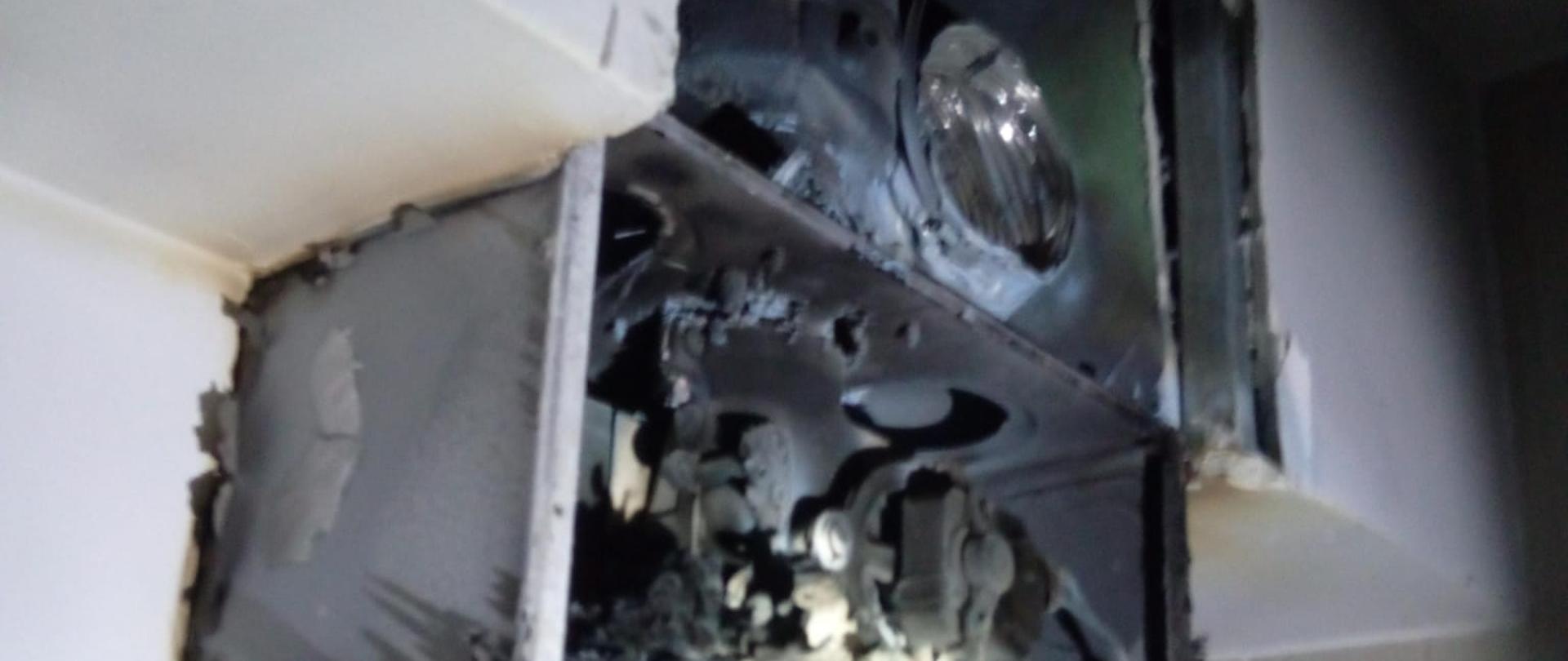 Zdjęcie przedstawia fragment gazowego podgrzewacza bieżącej wody po pożarze