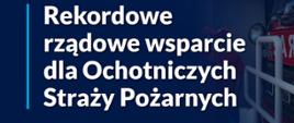 Baner reklamowy w odcieniu ciemnoniebieskim z napisem "Rekordowe rządowe wsparcie dla Ochotniczych Straży Pożarnych 675 nowych wozów dla OSP" Po prawej stronie przód samochodu ratowniczo gaśniczego. 