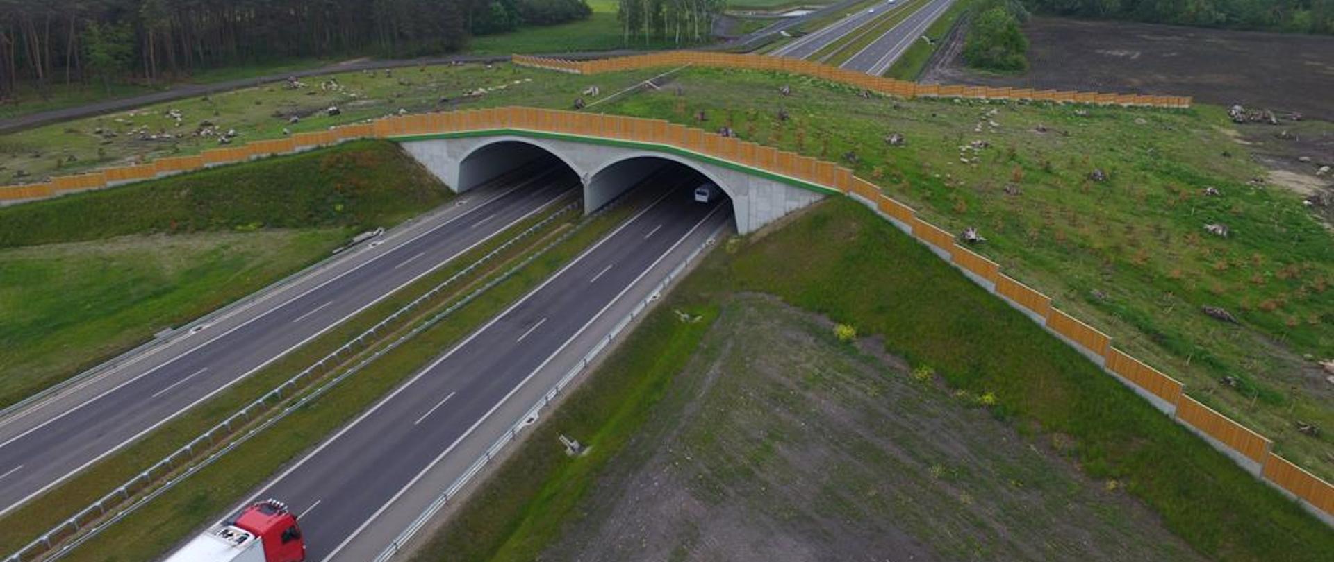 Zdjęcie przedstawia przejście dla zwierząt nad drogą ekspresową. Widok z lotu ptaka.